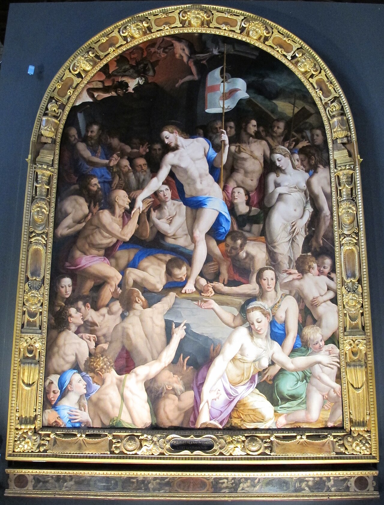中央のキリストへ裸身の人々が腕や顔を向ける。上部がアーチ形の祭壇画を金色の額が囲む。