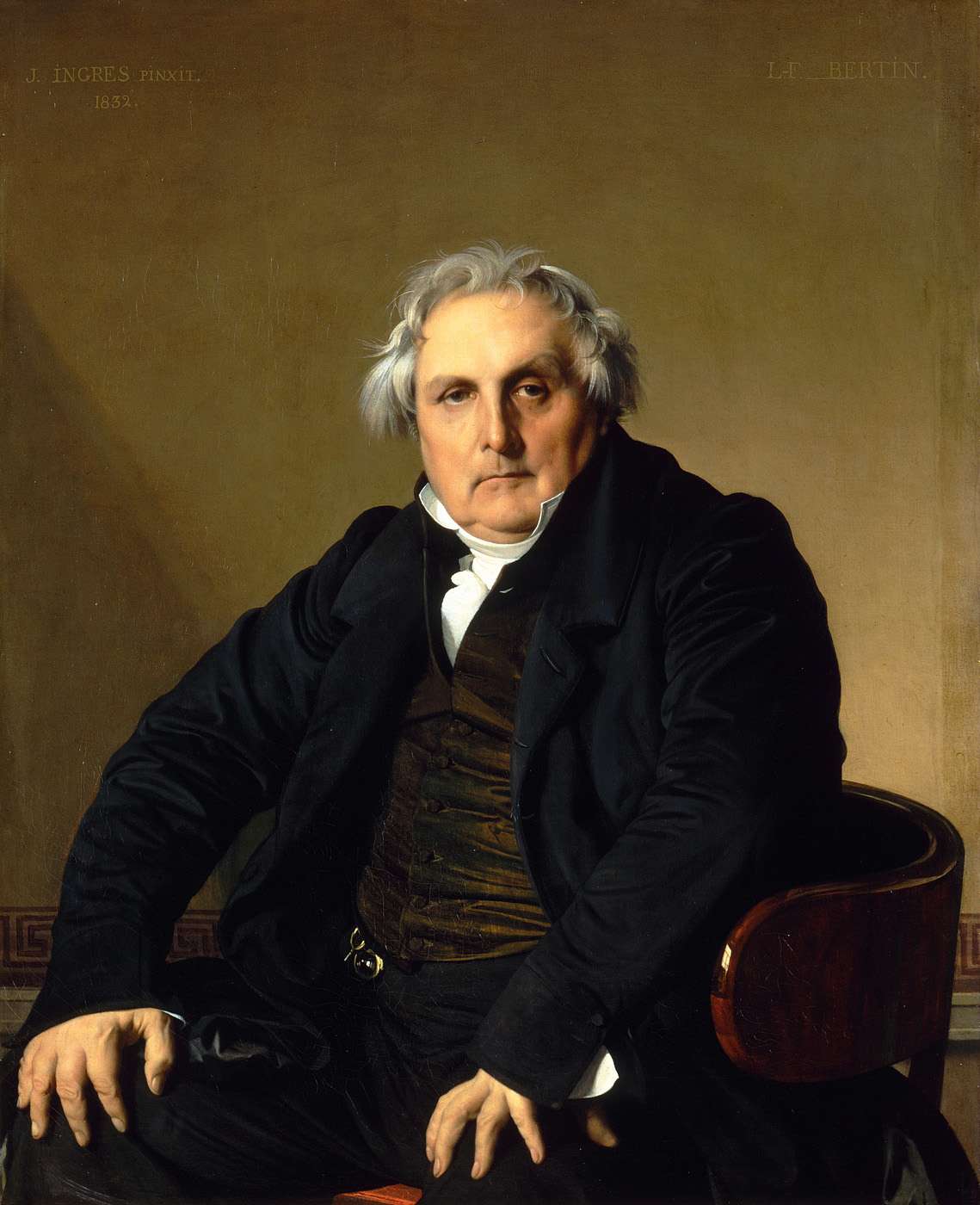 黒い上着のベルタン氏が椅子に座り、両手を膝につけてこちらを見つめる。